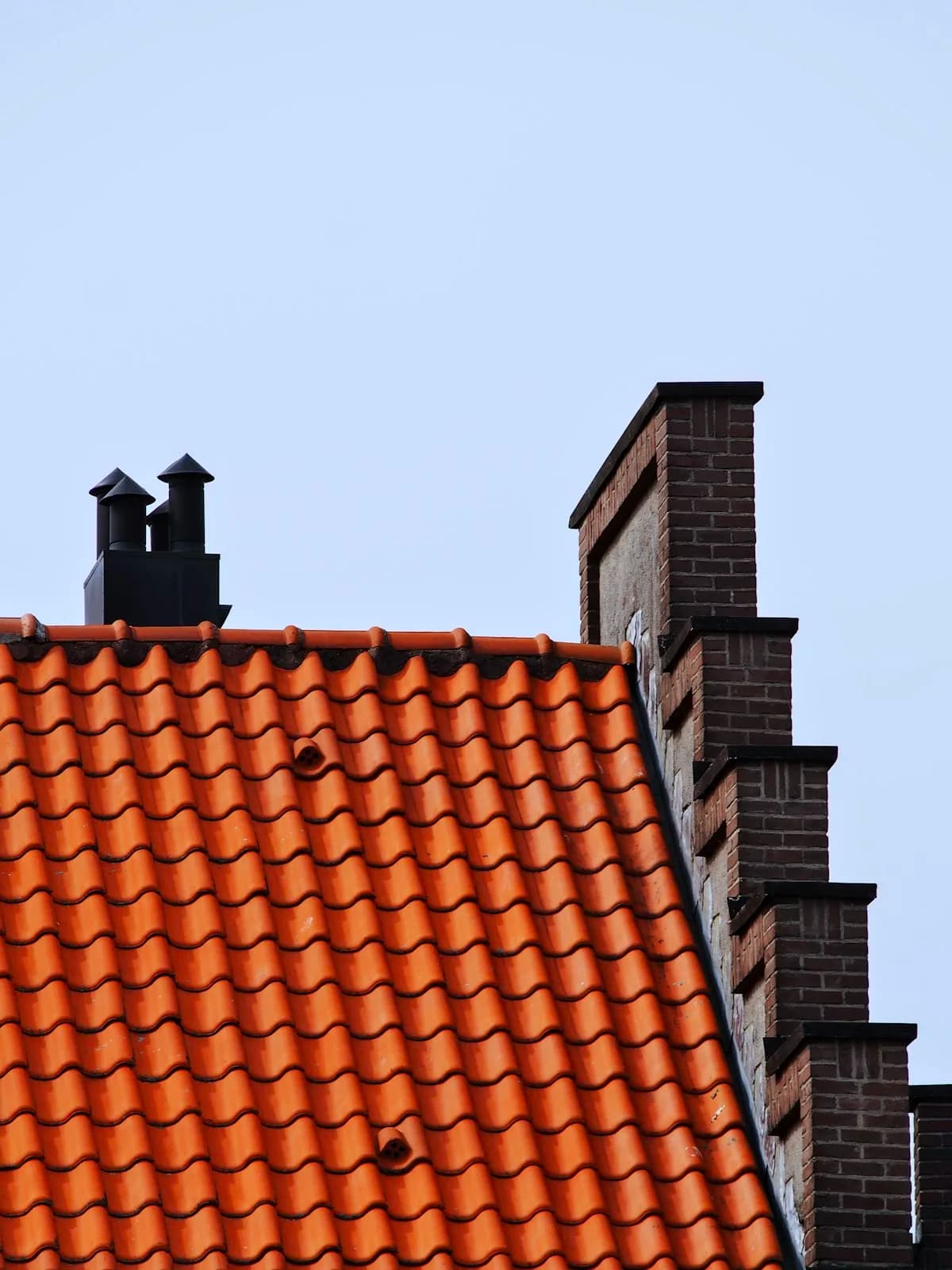 A crow-stepped brick gable beside an orange pantile roof